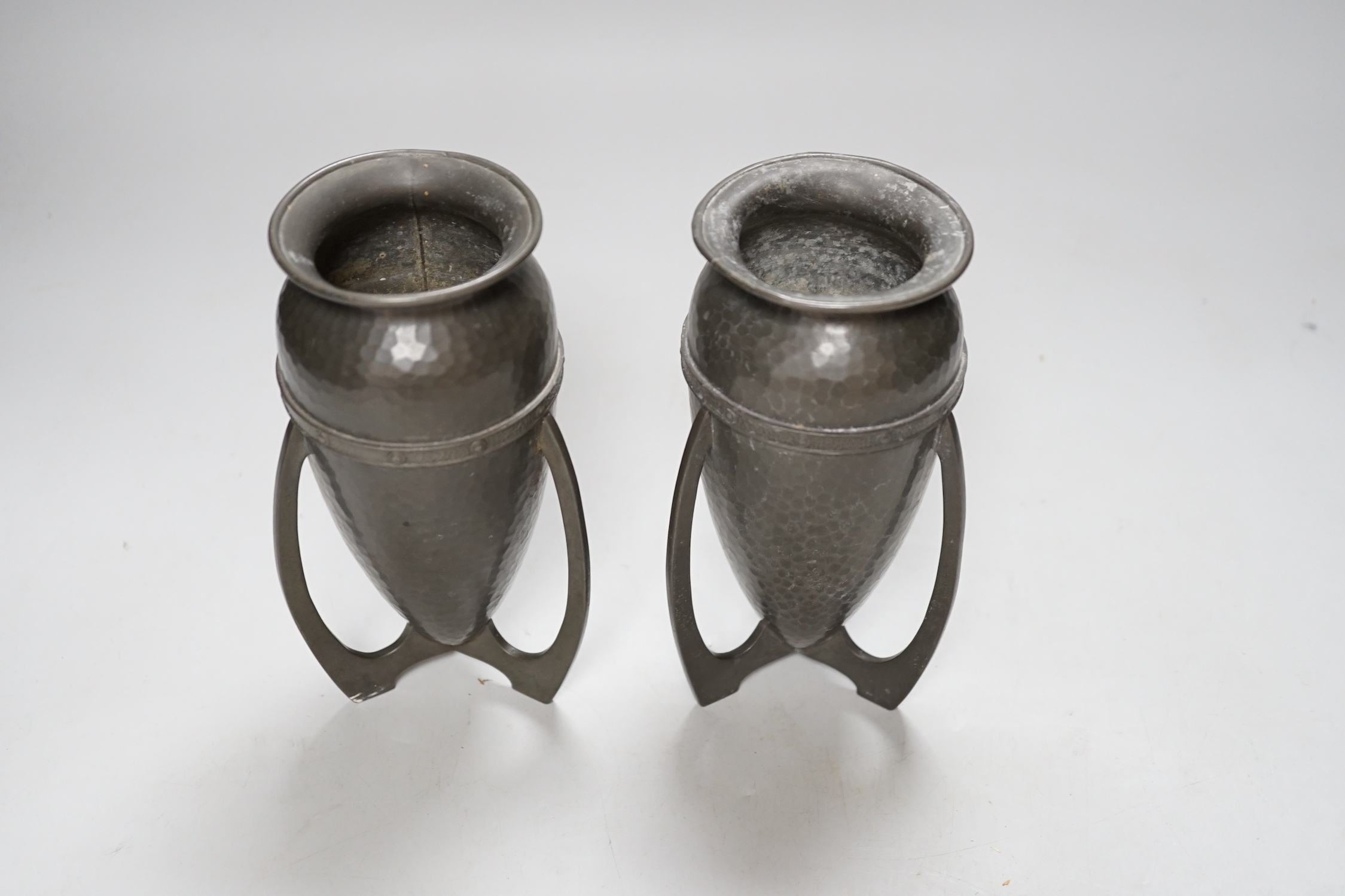 After Archibald Knox, pair of Art Nouveau style hammered pewter vases, 17cm high